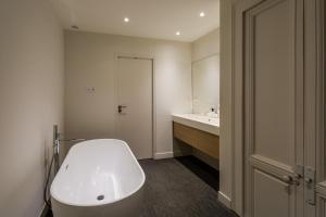 łazienka z białą wanną i umywalką w obiekcie Appartement design au coeur de Rennes w mieście Rennes