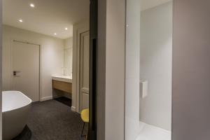 łazienka z białą wanną i umywalką w obiekcie Appartement design au coeur de Rennes w mieście Rennes