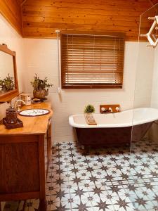 a bathroom with a bath tub and a sink and a tub at Paradise Lodge - Blue Mountains Wonderland in Linden
