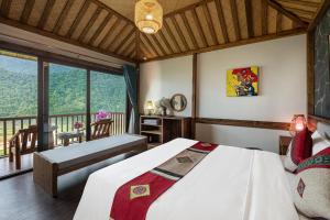 1 dormitorio con 1 cama grande y balcón en Sin Chai Ecolodge, en Sa Pa