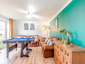 a living room with a ping pong table and a couch at Hill House in Sholden