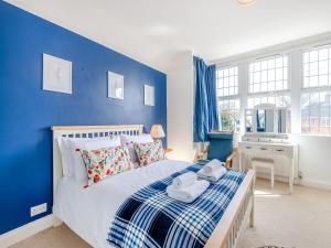 a blue bedroom with a bed with towels on it at Hill House in Sholden