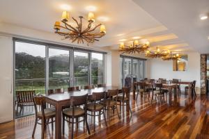 a dining room with tables and chairs and large windows at Kooloora Lodge in Perisher Valley