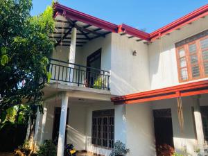 a large white house with a balcony at Sensitha Holiday home in Anuradhapura