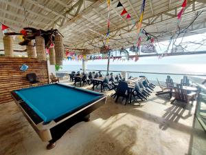 una mesa de billar en una habitación con mesas y sillas en Surigao Dream Beach Resort en Tigbao