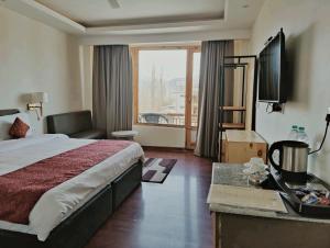 a hotel room with a bed and a large window at Yarab Tso in Leh