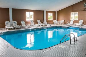 una gran piscina en una habitación de hotel con tumbonas en Country Inn & Suites by Radisson, Battle Creek, MI, en Battle Creek