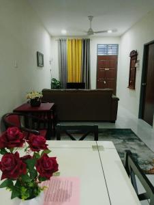 a living room with a table with roses on it at Homestay CikguRose UMK in Bachok