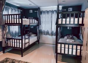 喬木提恩海灘的住宿－A title Guestel jomtien，蓝色墙壁的客房内设有两张双层床。