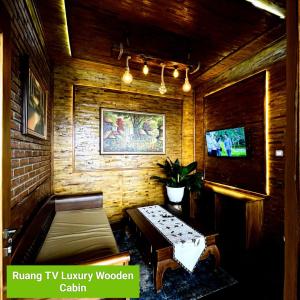 a living room with a bench and a tv at Bagas Luxury Camp in Kejajar