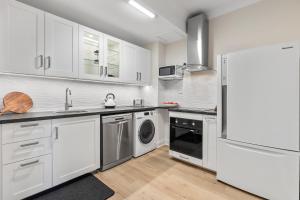 古尔瓦Cadell Street Apartments Goolwa的配有白色橱柜、洗衣机和烘干机的厨房 更多17张照片