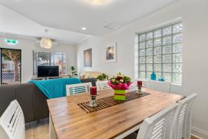 a dining room and living room with a wooden table at Cadell Street Apartments Goolwa in Goolwa