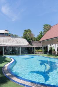 a swimming pool in front of a building at บ้านนารีสอร์ท in Nakhon Nayok