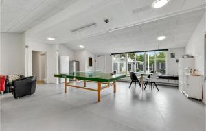 a living room with a ping pong table and chairs at 8 Bedroom Cozy Home In Henne in Henne