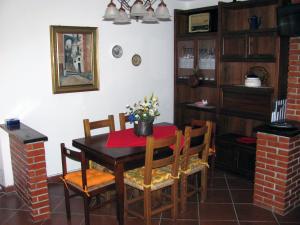 ein Esszimmer mit einem Holztisch und Stühlen in der Unterkunft Agriturismo Il Giglio e la Rosa in Montale