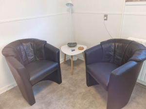 two leather chairs and a table in a room at Feriehuse Hvide Sande in Hvide Sande