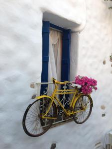 a yellow bike parked in front of a window with flowers at Plaka Villa 2 Naxos in Plaka
