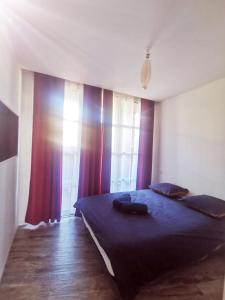 - une chambre avec un grand lit et des rideaux violets dans l'établissement Appartement dans Village vacances vue mer, à Saint-Raphaël