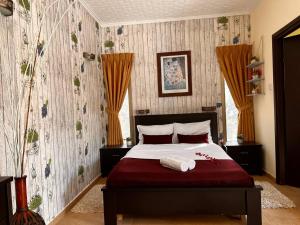 een slaapkamer met een groot bed met rode lakens en bloemen bij skyZimmer network-Ahuzat omanim in Ani'am