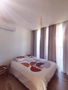 - une chambre avec un lit dans une pièce dotée de fenêtres dans l'établissement Appartement dans Village vacances vue mer, à Saint-Raphaël