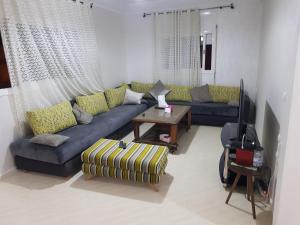 a living room with a blue couch and a table at Etage Villa Mehdia Amrya Plage N 277 in Kenitra