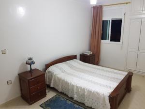 a bedroom with a bed and a dresser and a window at Etage Villa Mehdia Amrya Plage N 277 in Kenitra