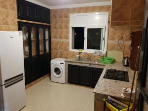 a kitchen with a sink and a washing machine at Etage Villa Mehdia Amrya Plage N 277 in Kenitra
