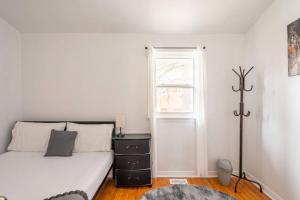 um quarto branco com uma cama e uma janela em Harmony Home Near University of Waterloo em Waterloo