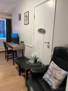 a living room with a couch and a table with a desk at Stor-Elvdal Hotell in Koppang