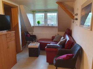 a living room with two couches and a tv at Fewo-hierundjetzt Lichtenhain am Malerweg in Lichtenhain