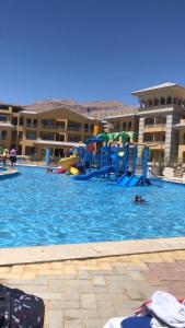 a swimming pool with a playground in a resort at شقه للايجار بورتو السخنه ألعاب مائية فرش مميز فندقي مكيفه in Ain Sokhna