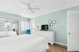 a bedroom with a white bed and a ceiling fan at Holiday Surf and Racquet Club 710 in Destin +39 photos