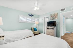 1 Schlafzimmer mit 2 Betten und einem Flachbild-TV in der Unterkunft Holiday Surf and Racquet Club 710 in Destin