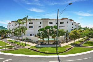 ein großes weißes Gebäude mit Palmen und einer Straße in der Unterkunft Belle Escapes Waterview Penthouse 404 The Edge in Cairns