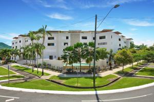 a large white building with palm trees and a street at Belle Escapes 404 The Edge with Views in Cairns