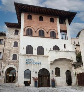 een groot bakstenen gebouw met een bord erop bij Hotel Gattapone in Gubbio
