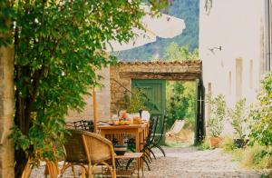 uma mesa e cadeiras num pátio num edifício em Maison d'Hôtes La Honas em La Rochette-du-Buis