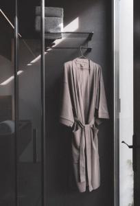 a robe hanging on a rack in a bathroom at Hotel Pepe Vieira Relais & Châteaux in Raxo