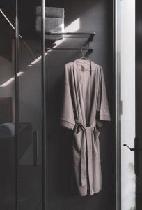 a robe hanging on a rack in a bathroom at Hotel Pepe Vieira in Raxó +52 photos