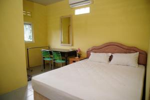 a bedroom with a bed and a table with chairs at Omah Bogem Homestay Syariah in Randugunting