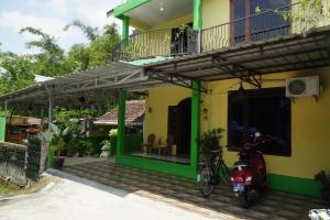 a house with a motorcycle parked in front of it at Omah Bogem Homestay Syariah in Randugunting