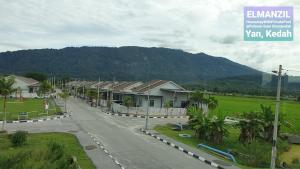 a view of a street with houses and a mountain at El Manzil Homestay with Pool in Guar Chempedak