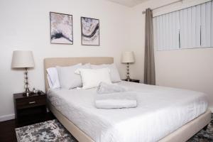 a bedroom with a bed with white sheets and pillows at Homey Oasis within minutes of San Diego adventures in San Diego
