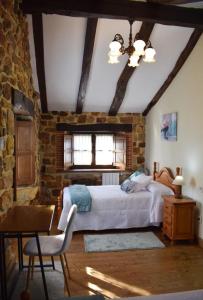 a bedroom with a bed and a brick wall at Casa Rural Los Riveros de Jeromo in Selaya