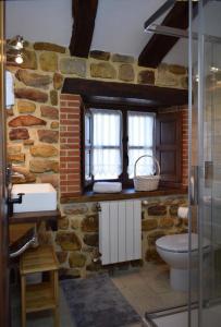 a stone bathroom with a toilet and a sink at Casa Rural Los Riveros de Jeromo in Selaya