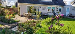 een tuin met een tafel, stoelen en bloemen bij Dajan in Almere
