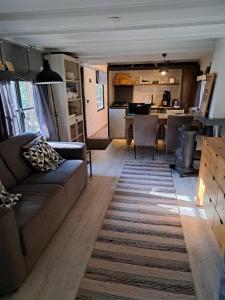 De Boshut Vledder في Vledder: غرفة معيشة مع أريكة ومطبخ