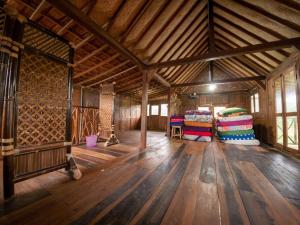 a large room with wooden floors and a wooden ceiling at Villa Watu kodok - Villa Located Close to The Beach in Baron +5 photos