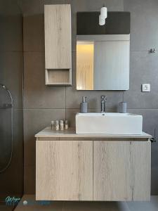 a bathroom with a sink and a mirror at Magic Kefalonia Villa in Spartia