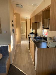 a small kitchen with a sink and a stove at 14 Greenwood Thorness Bay in Porchfield
